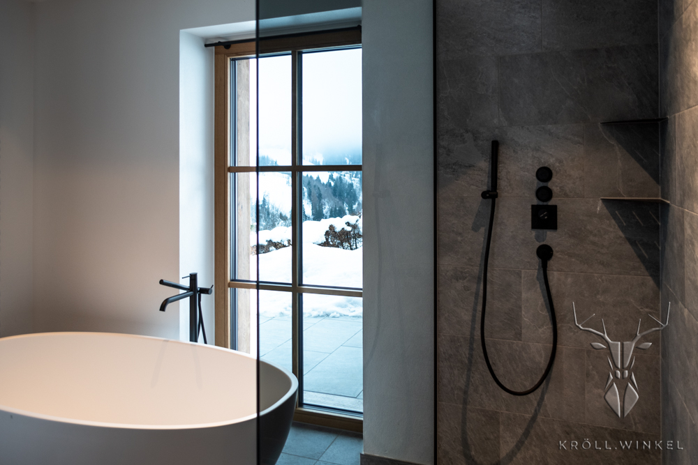 Badezimmer Chalet Badewanne schwarze Armaturen Steindusche