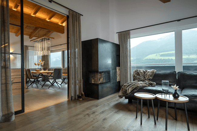 Interieurdesign mit Eichenküche, Eichentisch, Schwarzstahl Kamin und Buffelleder Couch