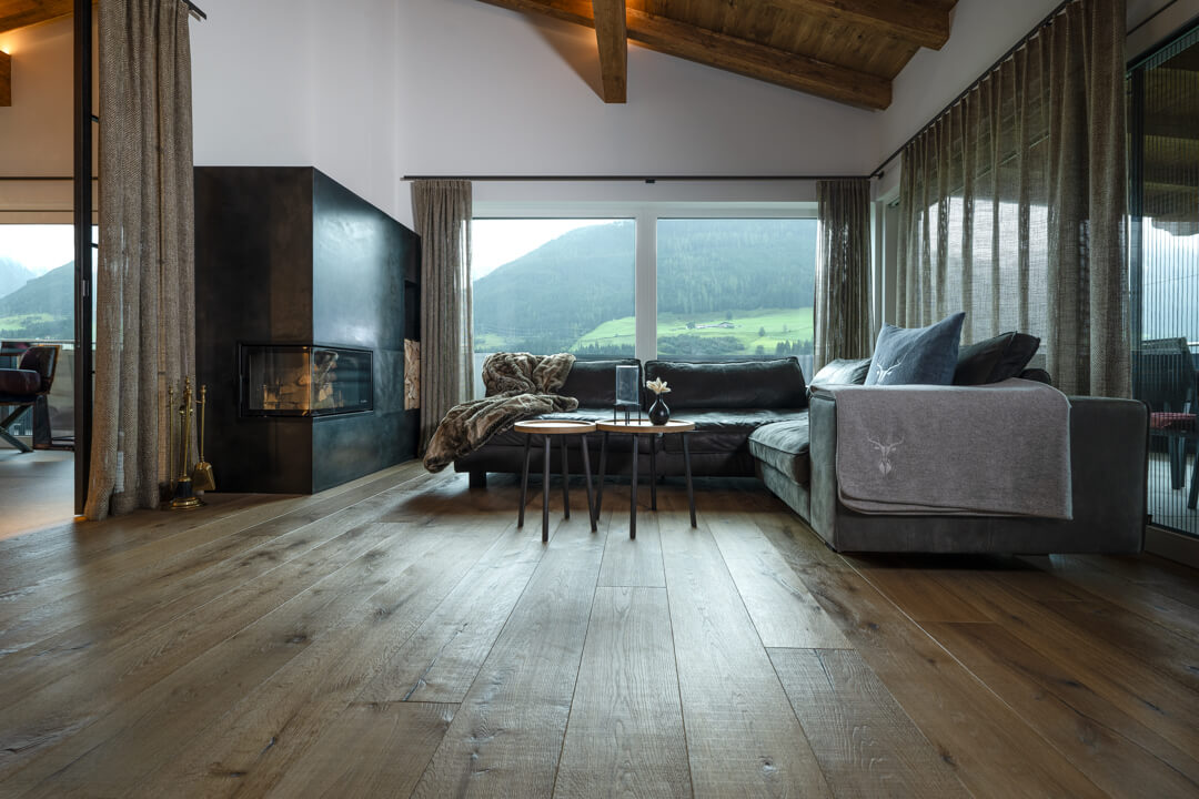 Wohnzimmer mit Stahlkamin, Eichen Fußboden und Buffelledercouch