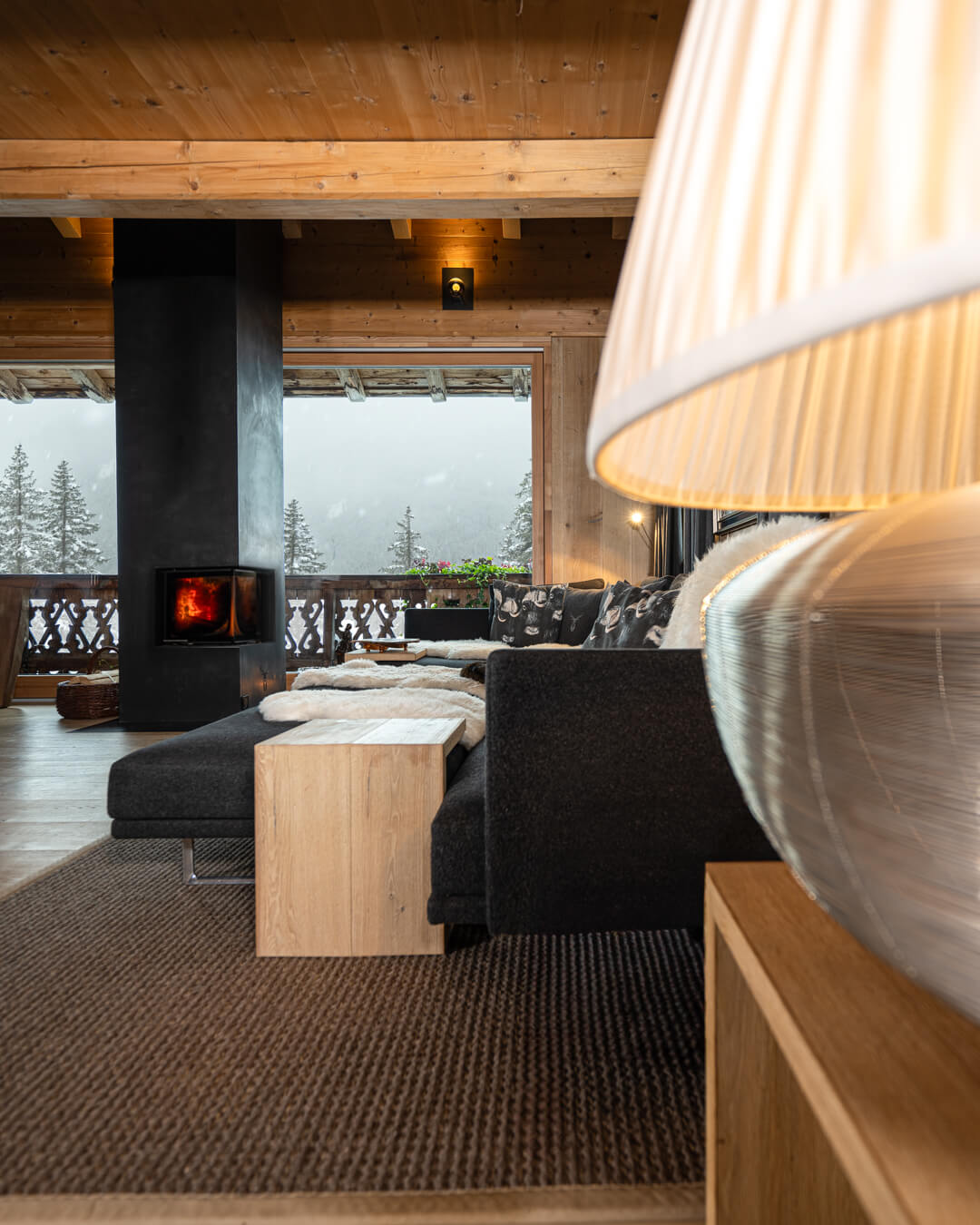 Wohnzimmer Chalet mit Stahlkamin, strukturierter Teppich und Loden Sofa