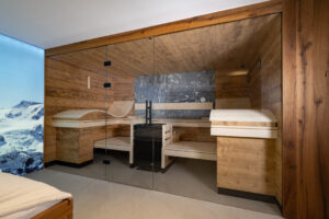 Altholz-Sauna aus Fichte mit rauem grauen Naturstein