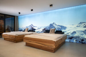 Wellness-Relax-Bett aus Eiche mit dahinter eine Fotoleinwand mit winterlicher Berglandschaft.