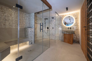 Dampfsauna und begehbare schwarze Regendusche mit Fliesen aus Muschelperlmutt