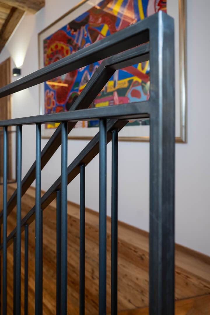 Chalet mit Stahlgeländer, Altholzverkleidung und Kunst in komplementären Farben.