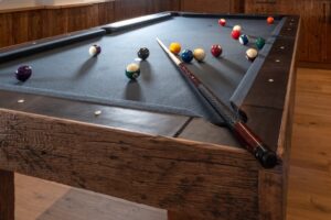 Rustikaler Billardtisch mit Altholz und Leder im Chalet-Stil