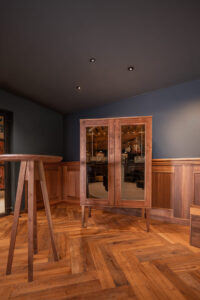 Handgefertigter Whiskyschrank aus Walnussholz mit getöntem Glas. Geschlossen.