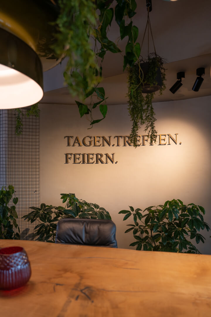 Moderner Wandschriftzug aus Bronze mit den Begriffen ‚Tagen, Treffen, Feiern