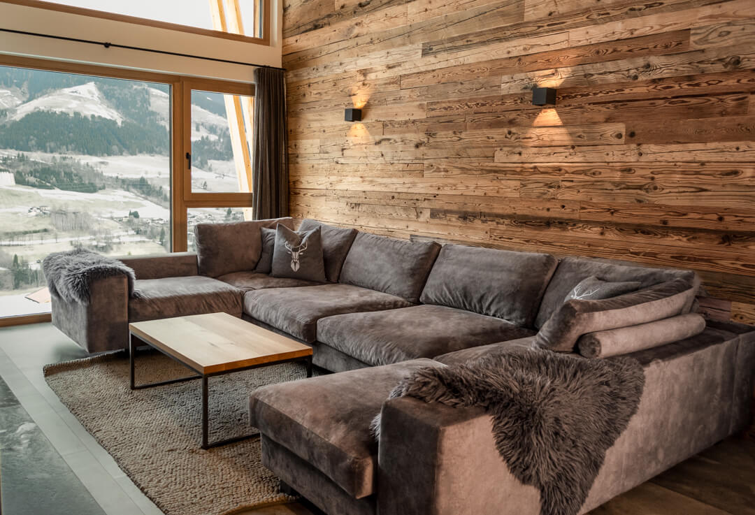 Altholzwand mit Sofalandschaft