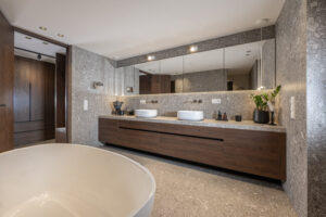 Badezimmer, dunkler Eichenwaschtisch, marmorierte, graue Fliesen