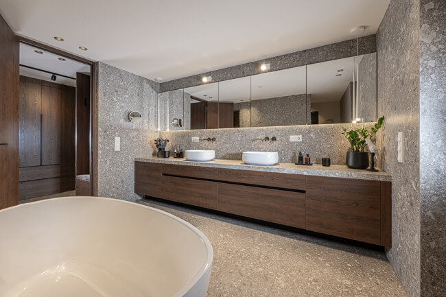 Badezimmer, dunkler Eichenwaschtisch, marmorierte, graue Fliesen