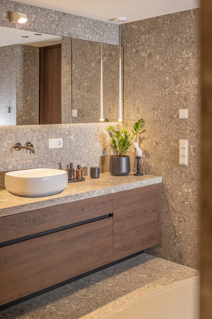 Badezimmer Möbel dunkles Holz und marmorierte Ivory-Fliesen.