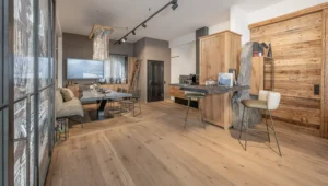 nterieur-Design-Showroom mit schwarzem Holztisch, Eichendielen und Eichenmöbeln – inklusive integrierter Felsenwand, Weinkühlschrank, Holzbar und passenden Hockern