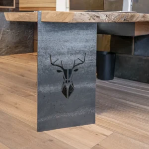 Schreibtisch mit massiver Holzplatte auf Stahlfuß mit Hirschmotiv.