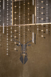 Lederwand mit Hirschmotiv und dekorativen Swarovski-Pendants.“