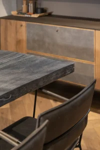 Dunkle Lederstühle, verkohlter Holztisch und wildlederbezogenes Eichen-Sideboard