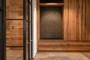 Entrée mit Einbauschrank aus Eichenholz und gepolsterter Wildleder-Sitzbank mit Rautenmuster.